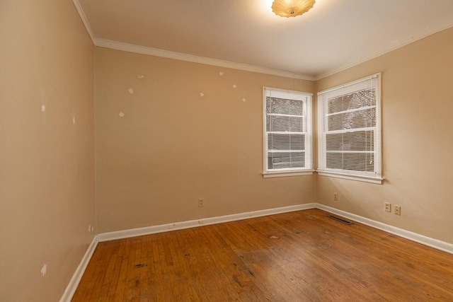 empty room featuring wood-type flooring and ornamental molding