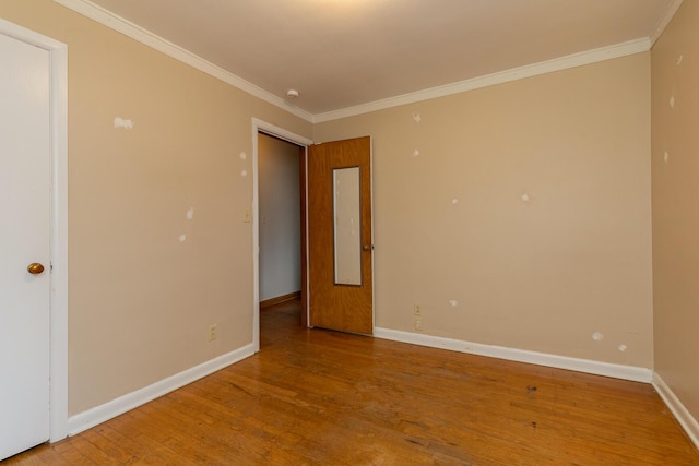 spare room featuring hardwood / wood-style flooring and crown molding