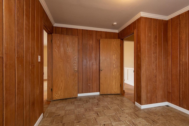 unfurnished bedroom with light parquet floors, ornamental molding, and wood walls