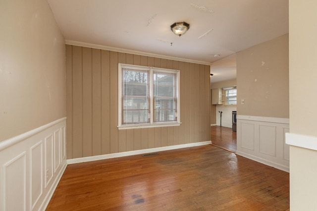 unfurnished room featuring ornamental molding and wood-type flooring