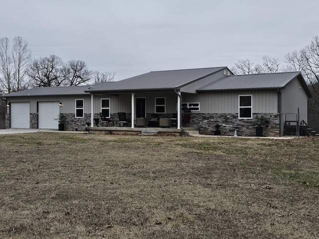 view of front of property featuring a garage, a front lawn, and covered porch