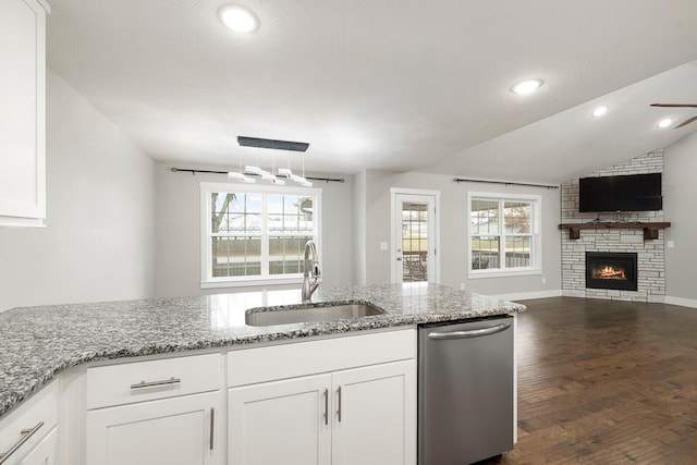 kitchen with dishwasher, sink, white cabinets, light stone countertops, and dark wood-type flooring