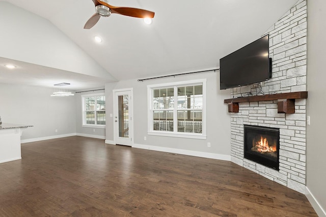 unfurnished living room featuring dark hardwood / wood-style floors, ceiling fan, a stone fireplace, and high vaulted ceiling