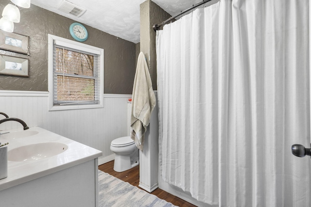 bathroom with vanity, hardwood / wood-style flooring, toilet, and walk in shower