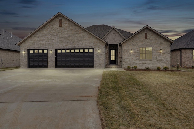 view of front facade featuring a garage and a lawn