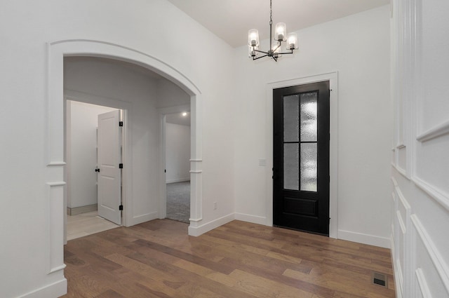 foyer featuring wood-type flooring and a chandelier