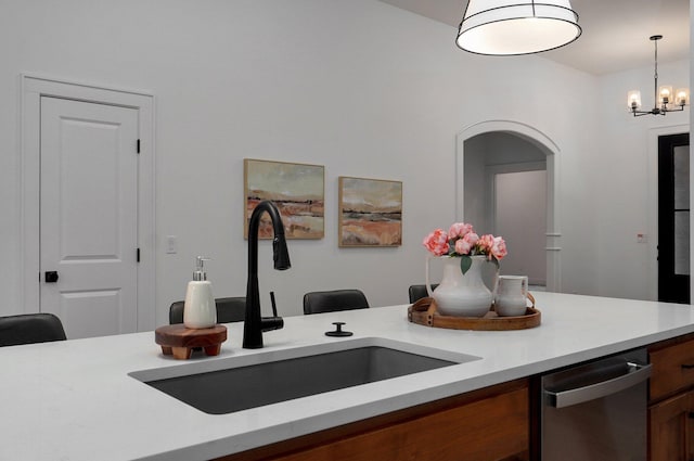 kitchen with hanging light fixtures, stainless steel dishwasher, sink, and a chandelier