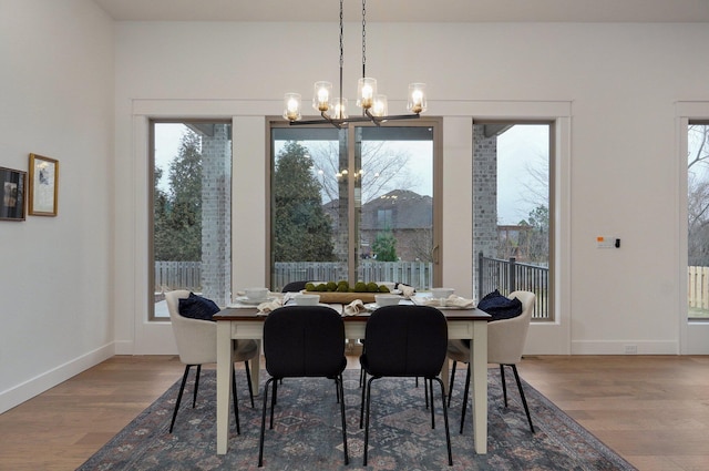 dining area featuring hardwood / wood-style flooring and a notable chandelier