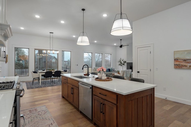 kitchen with pendant lighting, sink, an island with sink, and appliances with stainless steel finishes