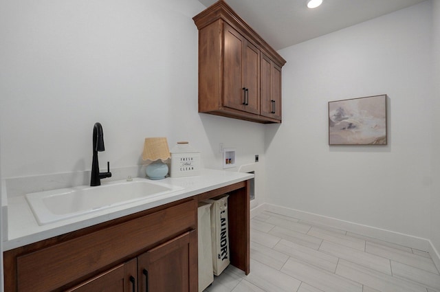 washroom featuring cabinets, hookup for an electric dryer, hookup for a washing machine, and sink