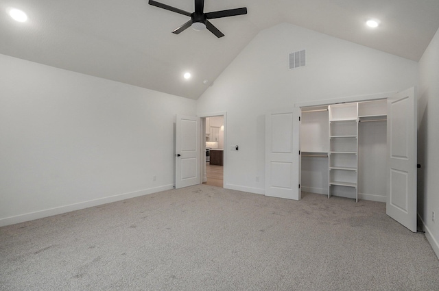 unfurnished bedroom featuring ceiling fan, light carpet, high vaulted ceiling, and a closet