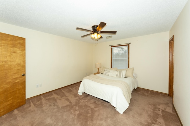 carpeted bedroom featuring ceiling fan and a textured ceiling