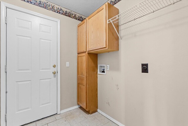 clothes washing area featuring electric dryer hookup, light tile patterned floors, hookup for a washing machine, and cabinets