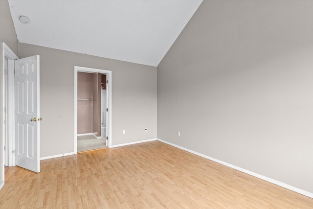 unfurnished bedroom with vaulted ceiling and light hardwood / wood-style flooring