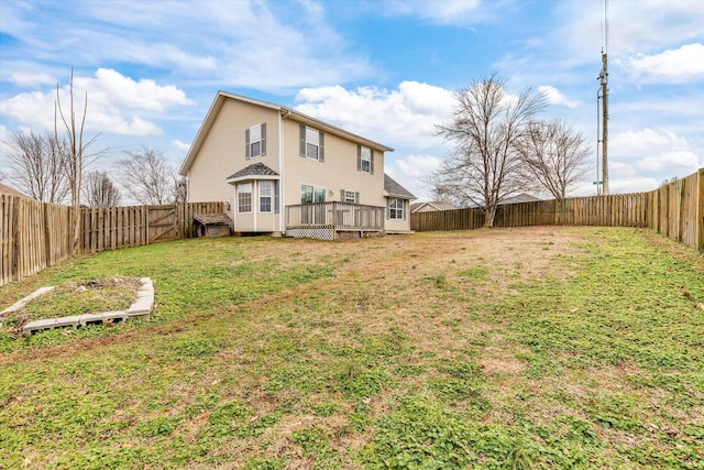 rear view of house with a yard and a deck