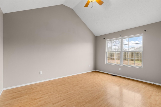 spare room with ceiling fan, lofted ceiling, and light hardwood / wood-style floors