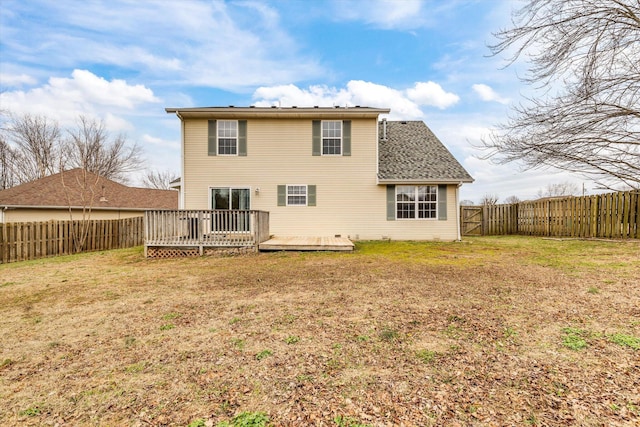 rear view of house featuring a yard and a deck