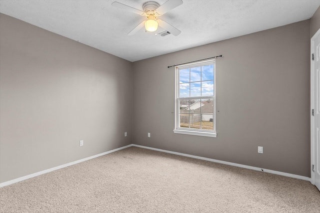 carpeted spare room with ceiling fan and a textured ceiling