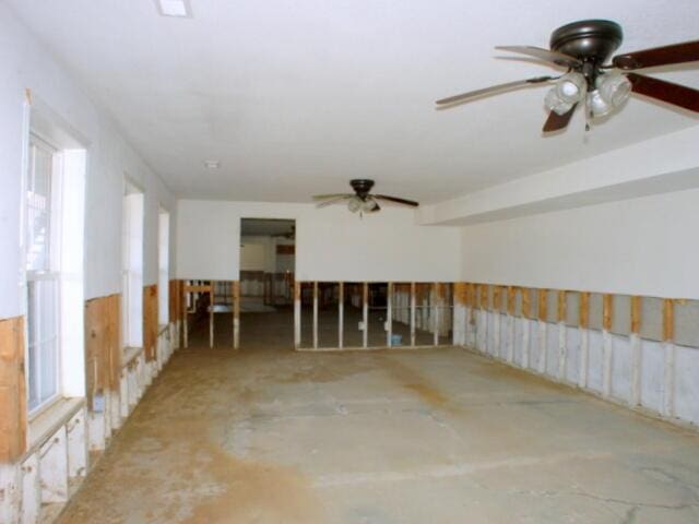 spare room with a ceiling fan and concrete flooring