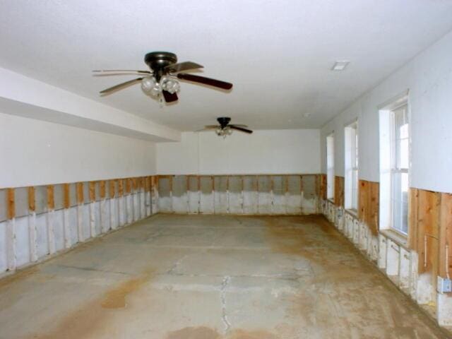 empty room with wainscoting and concrete floors