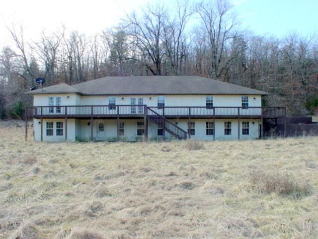 rear view of property featuring stairs and a deck