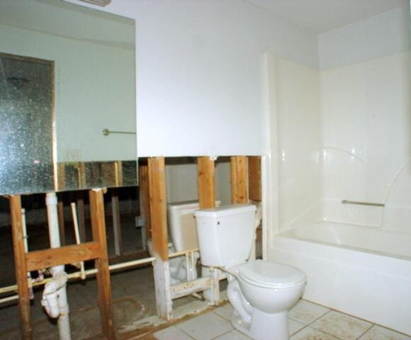 bathroom with toilet, tile patterned flooring, and bathtub / shower combination