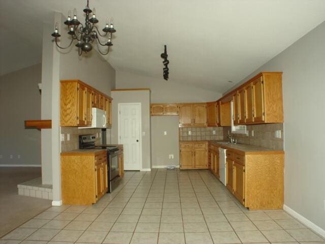 kitchen featuring white microwave, stainless steel electric range, vaulted ceiling, light countertops, and a sink