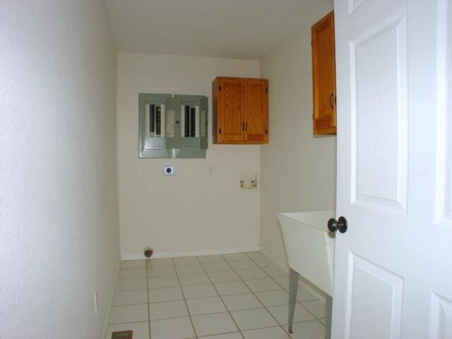 washroom with light tile patterned floors, washer hookup, cabinet space, electric panel, and electric dryer hookup