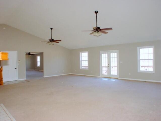 unfurnished living room featuring french doors, light colored carpet, ceiling fan, high vaulted ceiling, and baseboards