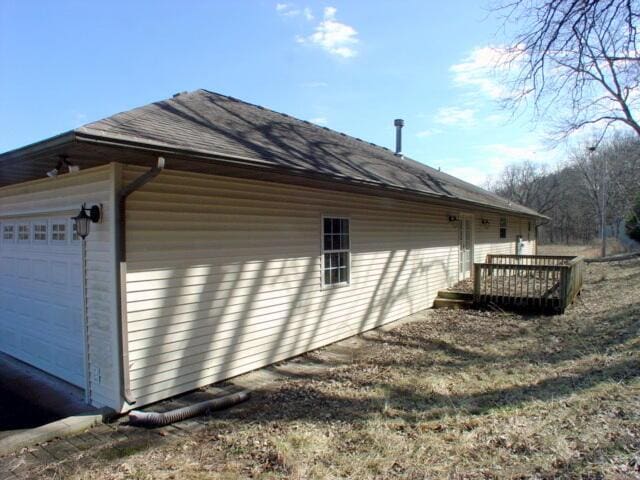 view of side of property with a garage and a deck