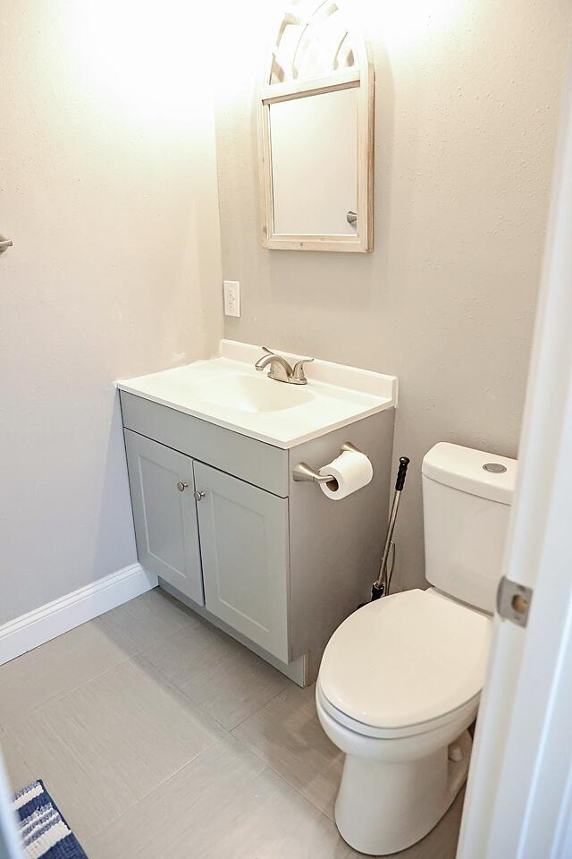 bathroom with vanity, tile patterned flooring, and toilet