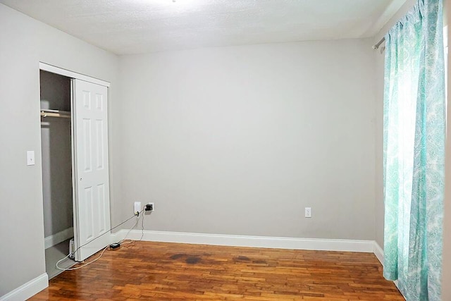 unfurnished bedroom with hardwood / wood-style floors and a closet