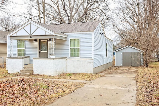 bungalow featuring a storage unit and covered porch