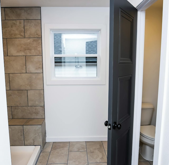 bathroom with a shower, tile patterned floors, and toilet