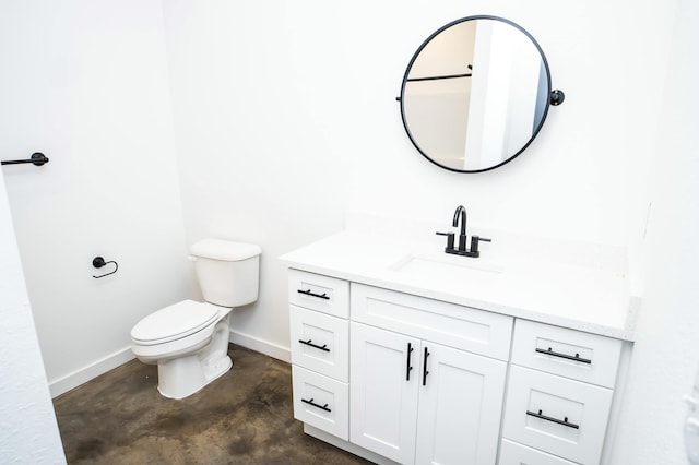 bathroom featuring vanity, concrete floors, and toilet