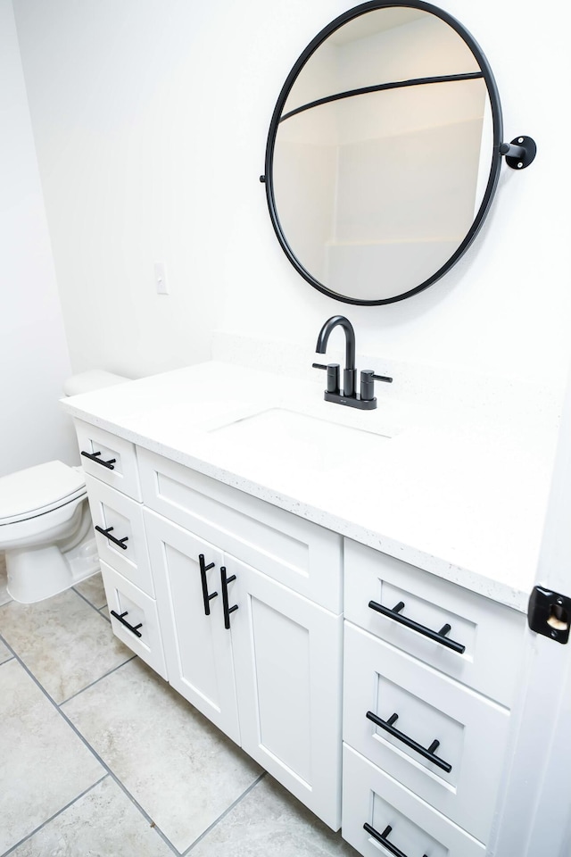 bathroom featuring vanity, tile patterned floors, and toilet