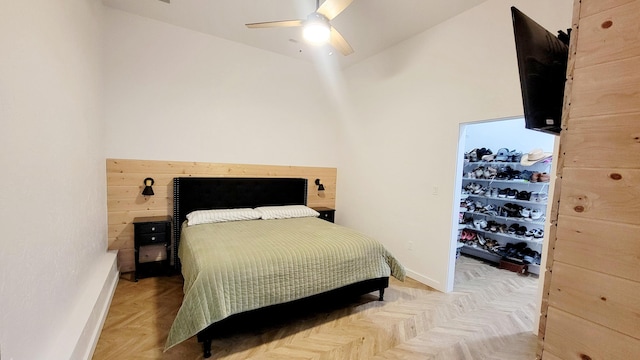 bedroom featuring ceiling fan, a towering ceiling, and light parquet floors