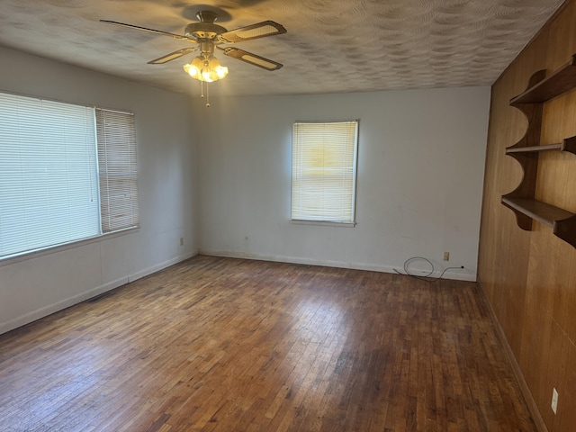 spare room featuring a textured ceiling, dark wood-type flooring, and ceiling fan