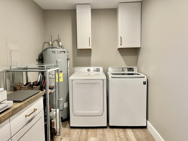 clothes washing area with cabinets, washer and clothes dryer, water heater, and light wood-type flooring