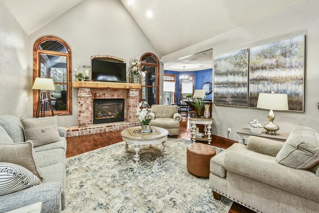 living room with hardwood / wood-style floors, vaulted ceiling, and a fireplace