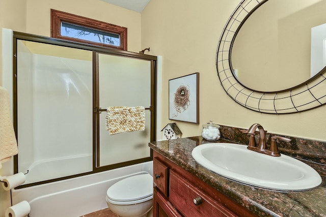 full bathroom with bath / shower combo with glass door, vanity, and toilet