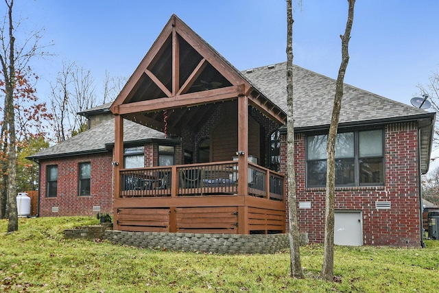 rear view of property featuring a lawn and a deck