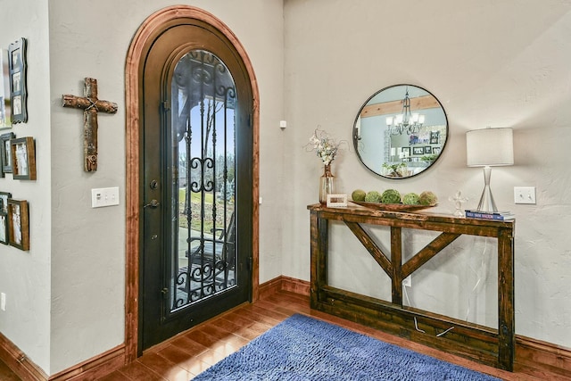 foyer featuring an inviting chandelier and wood-type flooring