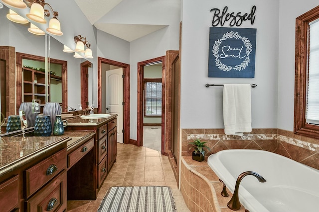 bathroom with tile patterned flooring, vanity, a relaxing tiled tub, and a chandelier