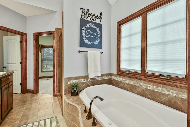 bathroom with vanity, tiled bath, and tile patterned flooring