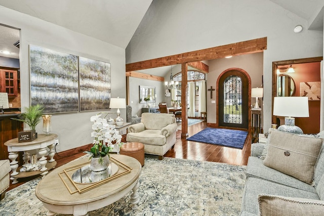 living room featuring an inviting chandelier, high vaulted ceiling, and hardwood / wood-style floors