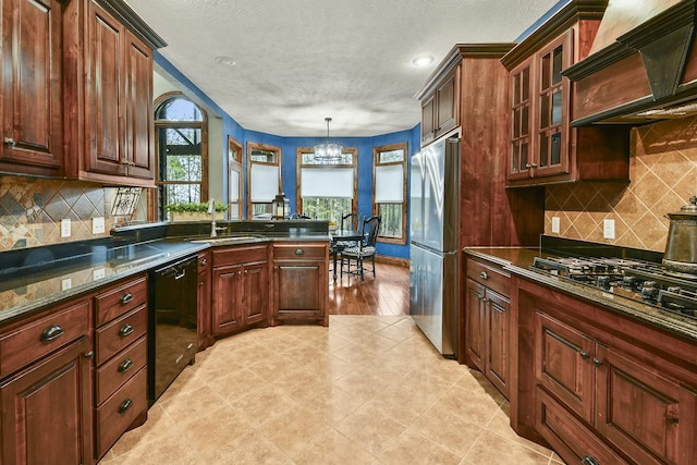 kitchen featuring premium range hood, a chandelier, pendant lighting, stainless steel appliances, and decorative backsplash