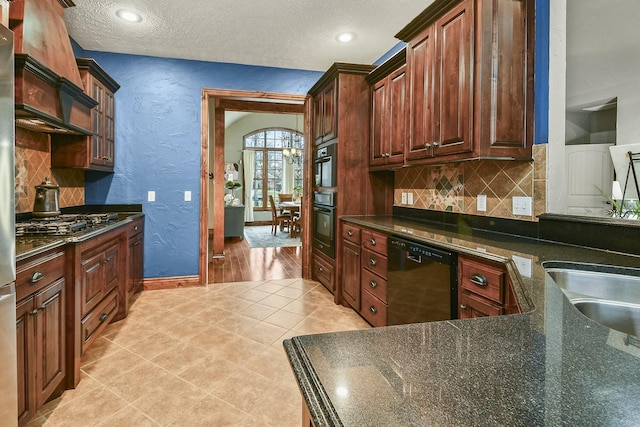 kitchen featuring light tile patterned floors, backsplash, a textured ceiling, and black appliances