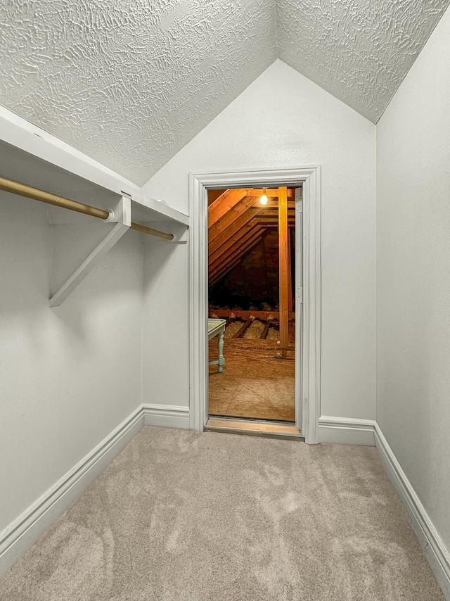 walk in closet featuring carpet flooring and vaulted ceiling