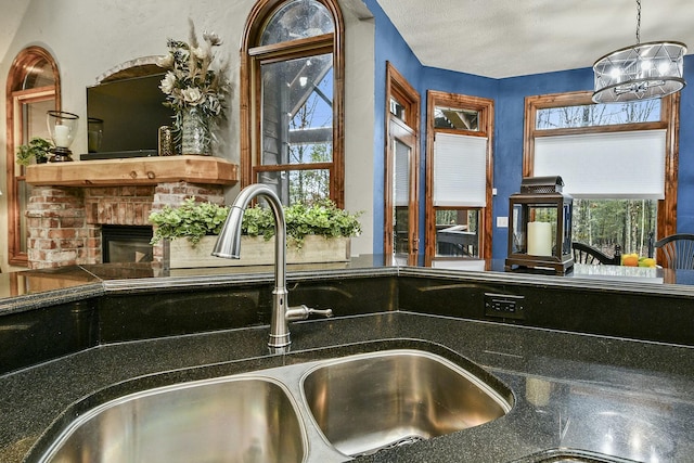 room details with a brick fireplace, sink, and a textured ceiling